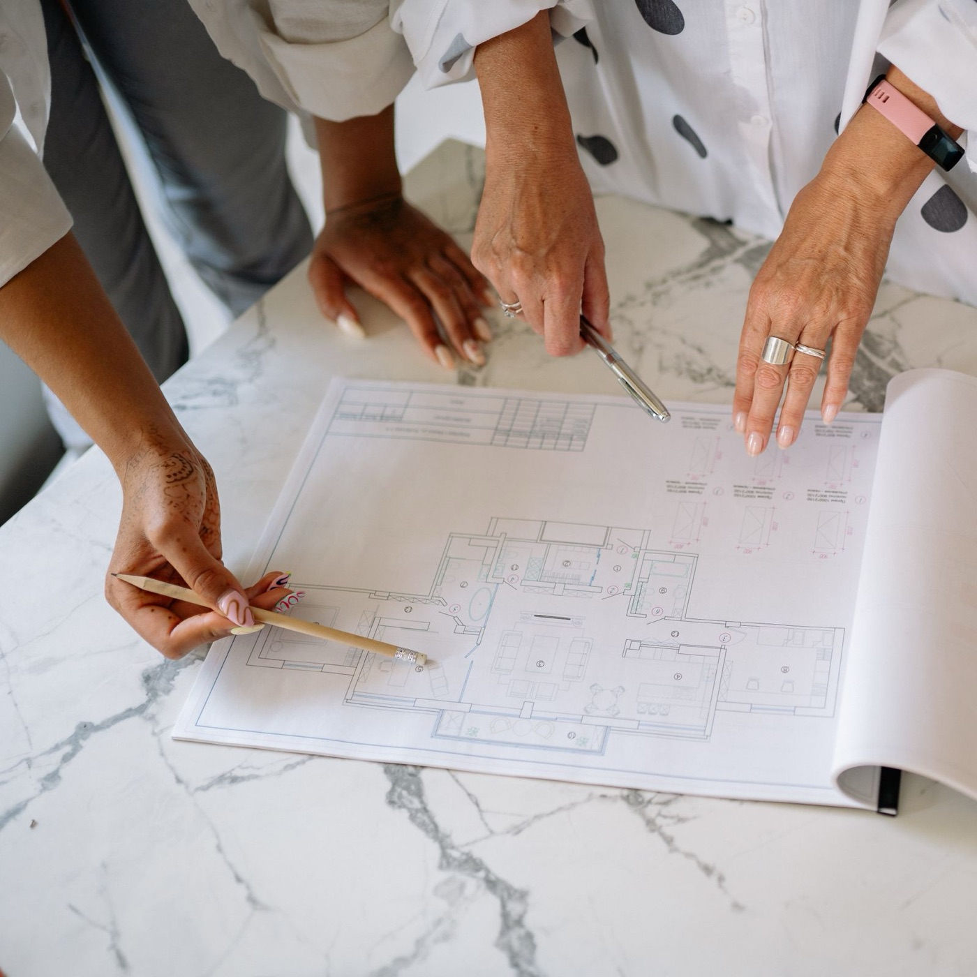 Hands reviewing architectural plans