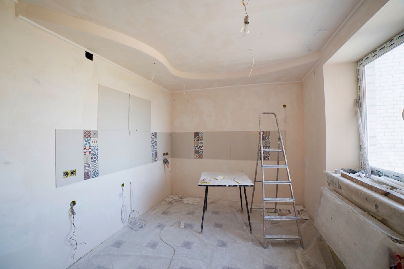 Kitchen under renovation with ladder and tools